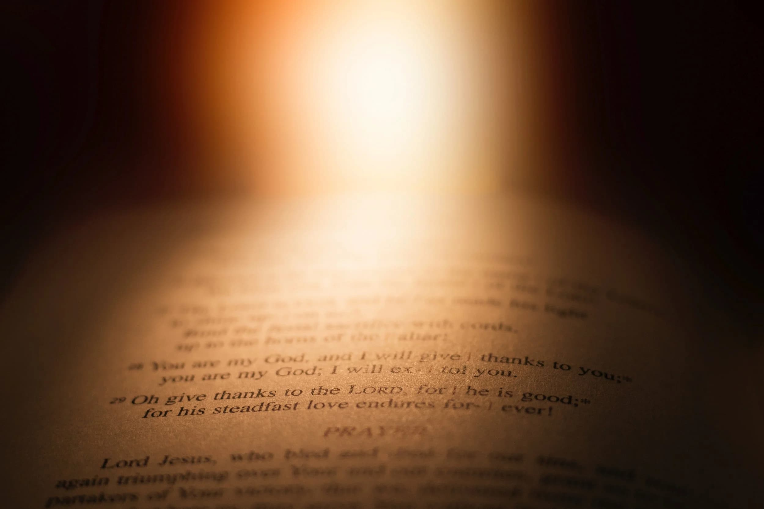 Open Bible illuminated by candlelight